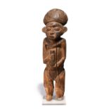 A Bamum standing figure Cameroon wearing a domed headdress and holding an ointment jar, 53cm high,