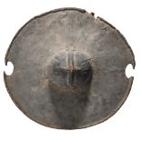 A Beja shield Sudan hide with a central boss having a ribbed cross motif, with a hide handle, 52.5cm