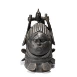 A Mende helmet mask Sierra Leone with a leaning figure surmount having glass bead inset eyes, 41.5cm