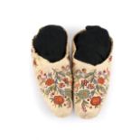 A pair of Cree moccasins Canada caribou hide and coloured silk thread, with finely embroidered