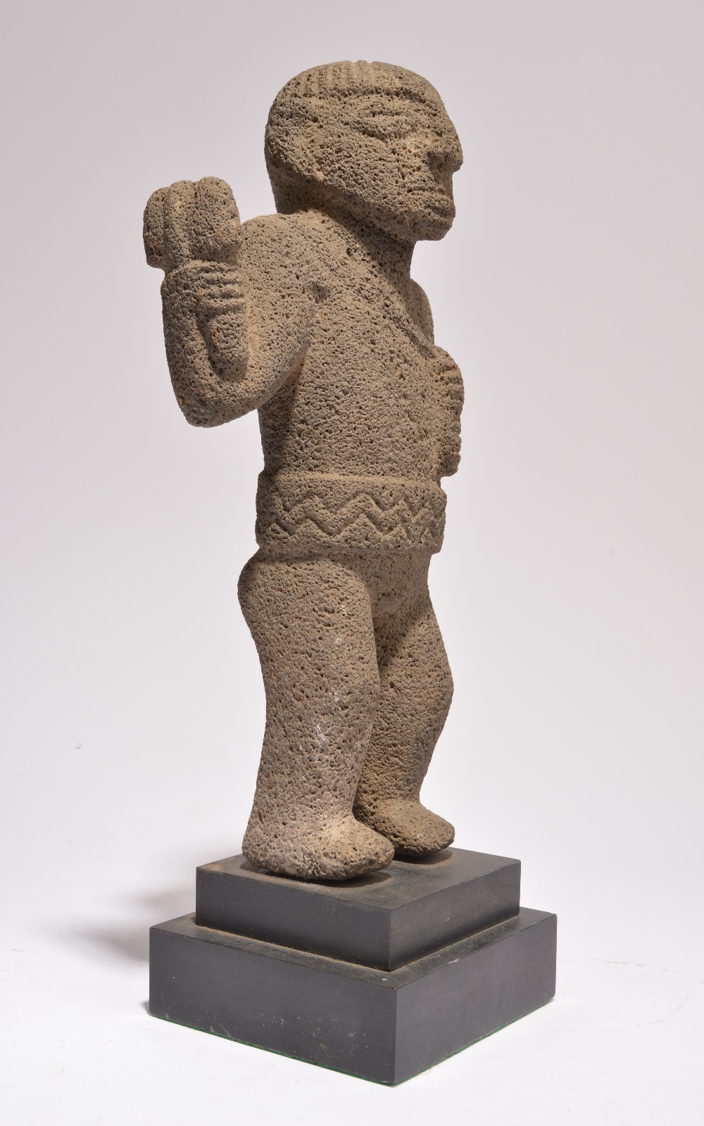 A Costa Rica standing figure volcanic rock, with a crossed and ribbed coiffure, holding an axe in - Image 3 of 3