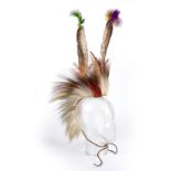 A Plains roach dyed porcupine hair and deer hair on woven cloth with a rawhide spreader with two