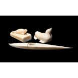 λThree Inuit carvings Baffin Island, Canada walrus ivory, including a model kayak, 15.6cm long and