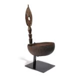 An Admiralty Islands ladle Papua New Guinea coconut shell, gum and carved wood, 29.5cm high, on a