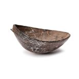 A Solomon Islands bowl Melanesia coconut shell with linear carving to the edge, 18.2cm long.