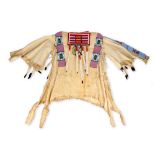 A buckskin shirt with Plateau area beadwork the fringed shirt with applied coloured glass bead