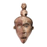 A Gabon mask with overlaid glass eyes and pigment decoration, 32cm high.