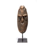 A Biwat mask Yuat River, Papua New Guinea with pierced eyes, nose and mouth, with remains of