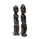 Two Baule standing figures Ivory Coast male and female with scarifications and hands placed on their