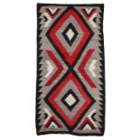 A Navajo rug Southwest North America with two serrated diamond medallions and chevrons, 177.5cm x