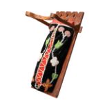 An Ojibwa dolls cradle board Canada the stained wood frame with a detachable bentwood head guard and
