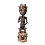 A Baule seated male figure Ivory Coast with pigment, 46cm high.