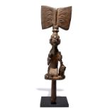 A Yoruba Shango wand Nigeria the kneeling figure holding a lightening stone and a tethered ram, with