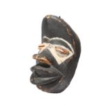 A Dan Wobe mask Liberia stained black and with white pigment, with a white painted inventory