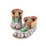 A pair of Western Sioux moccasins Plains buckskin, coloured glass beads, printed cotton and rawhide,