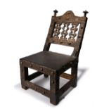 An Ashanti chair asipim Ghana wood, brass tacks and hide, the back with three open scroll edge