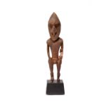 A Sepik River amulet figure Papua New Guinea standing male ancestor with a reddish pigment and