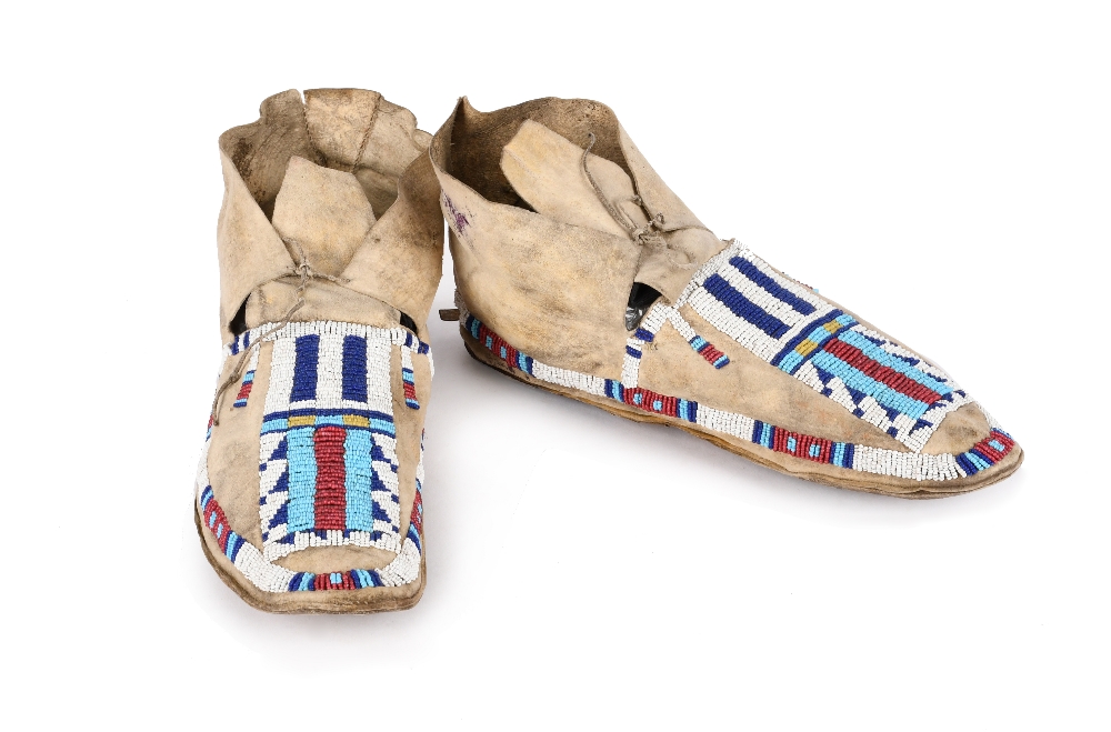 A pair of Cheyenne moccasins Plains buckskin, rawhide and coloured glass beads with geometric