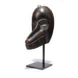 A Dan mask Ivory Coast with linear scarifications to the sides and a long projecting nose and jaw,