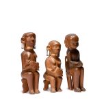Three Kamba seated figures Kenya two maternity with aluminium ear coils and eyes and leather