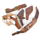 Two British service revolver holsters, a modern leather shoulder holster, a part .303 bandolier, and