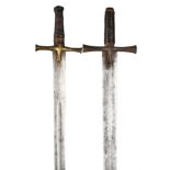 Two Sudanese swords (kaskara), each with broad double edged blades, cross hilts, and wood and