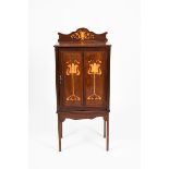 An Art Nouveau mahogany inlaid music cabinet, rectangular on tapering square section legs, the