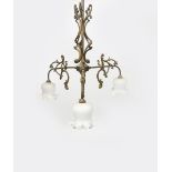 An Art Nouveau three light brass ceiling light, the three radiating stems cast with scrolling