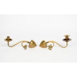 Two W A S Benson brass counterbalance candlesticks, each with seedpod counterweight and scrolling