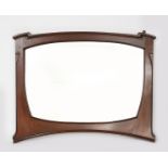 An Art Nouveau mahogany mirror, shaped, rectangular form with carved detailing, bevelled mirror