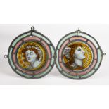 A pair of Aesthetic Movement stained glass Day and Night roundels, each painted with a portrait