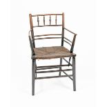 A Morris & Co Sussex ebonised wood armchair, turned legs with bobbin back, with rush seat
