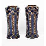 A near pair of Royal Doulton stoneware vases, slender waisted cylindrical form with inverted top