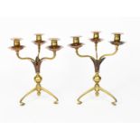 A pair of W A S Benson copper and brass three-light candlesticks, model no.22A, on angled tripod