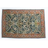 A wool carpet in the manner of Morris & Co, rectangular, decorated with floral cartouche panel