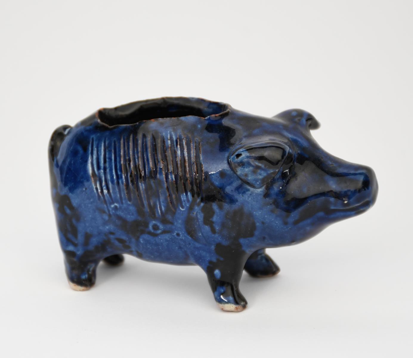 A Baron Barnstaple pottery pig vesta holder, naturalistically modelled and glazed blue, incised