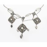 A silver and opal necklace designed by Kate Eadie, the main silver pendant cast and pierced with