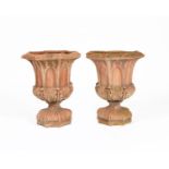 A pair of terracotta garden urns in the manner of Royal Doulton, octagonal section, each cast with