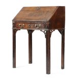 AN EARLY GEORGE III MAHOGANY BUREAU C.1760 on an integral stand, the hinged fall revealing six