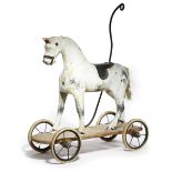 A PAINTED AND CARVED PINE PULL-ALONG TOY HORSE LATE 19TH / EARLY 20TH CENTURY with a wrought iron