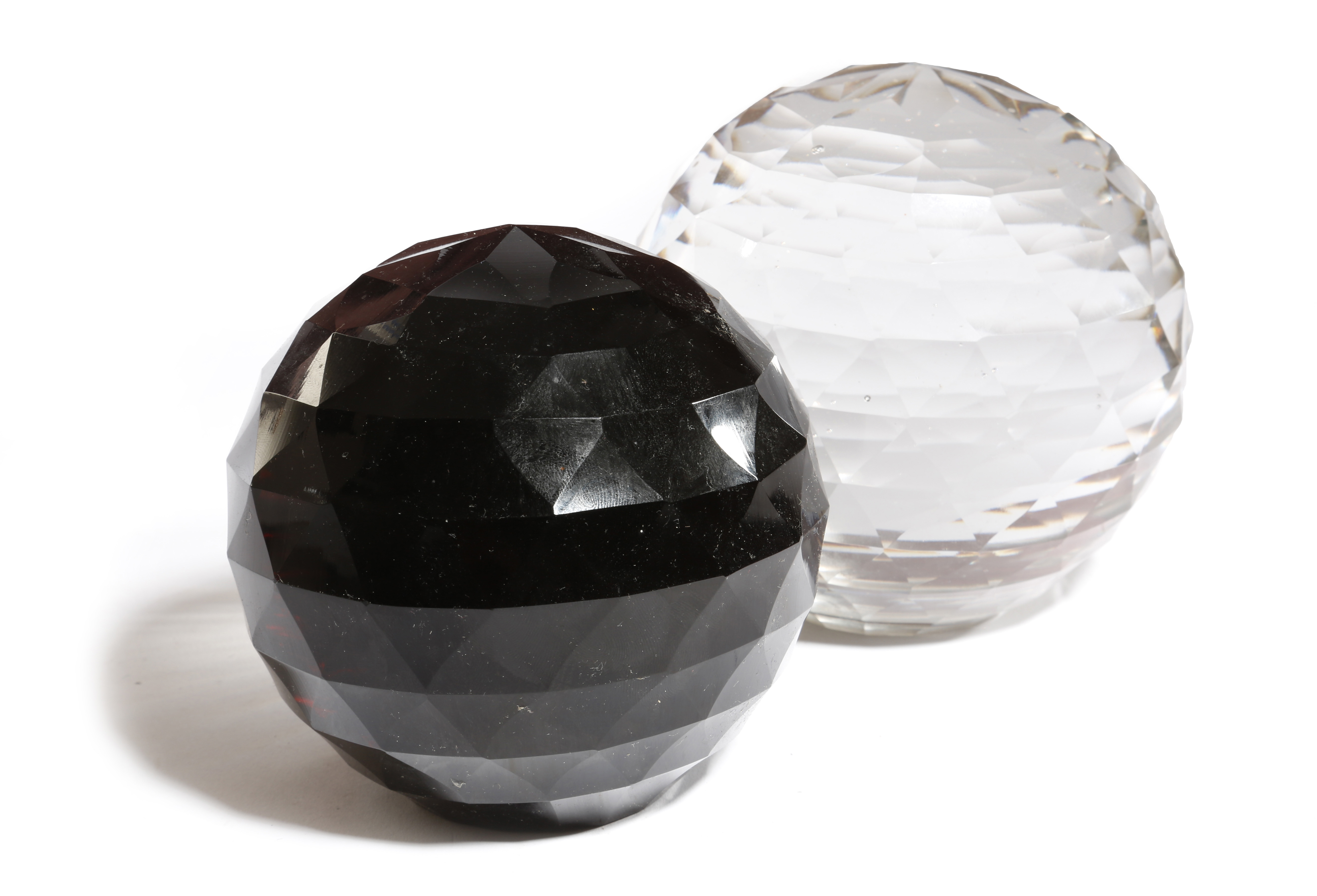 TWO FACETED GLASS BALL PAPERWEIGHTS LATE 19TH CENTURY one clear, the other black, each with a