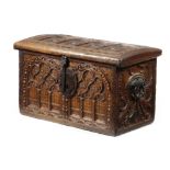 A FRENCH WALNUT COFFER IN GOTHIC STYLE the hinged lid carved with arches and an outer band of
