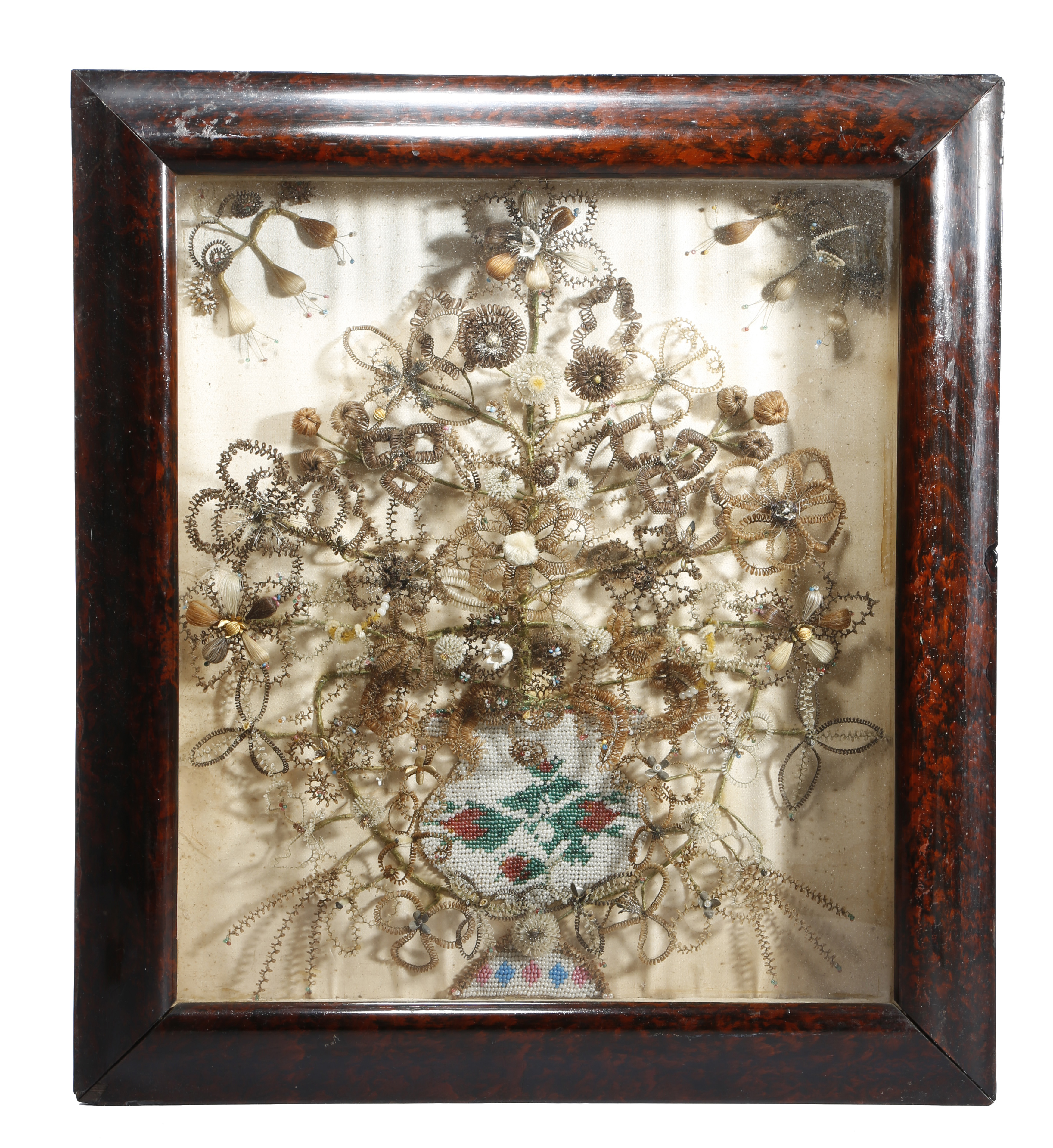 AN UNUSUAL VICTORIAN HAIR AND BEADWORK DIORAMA C.1840-50 depicting an urn of leaves and flowers, the