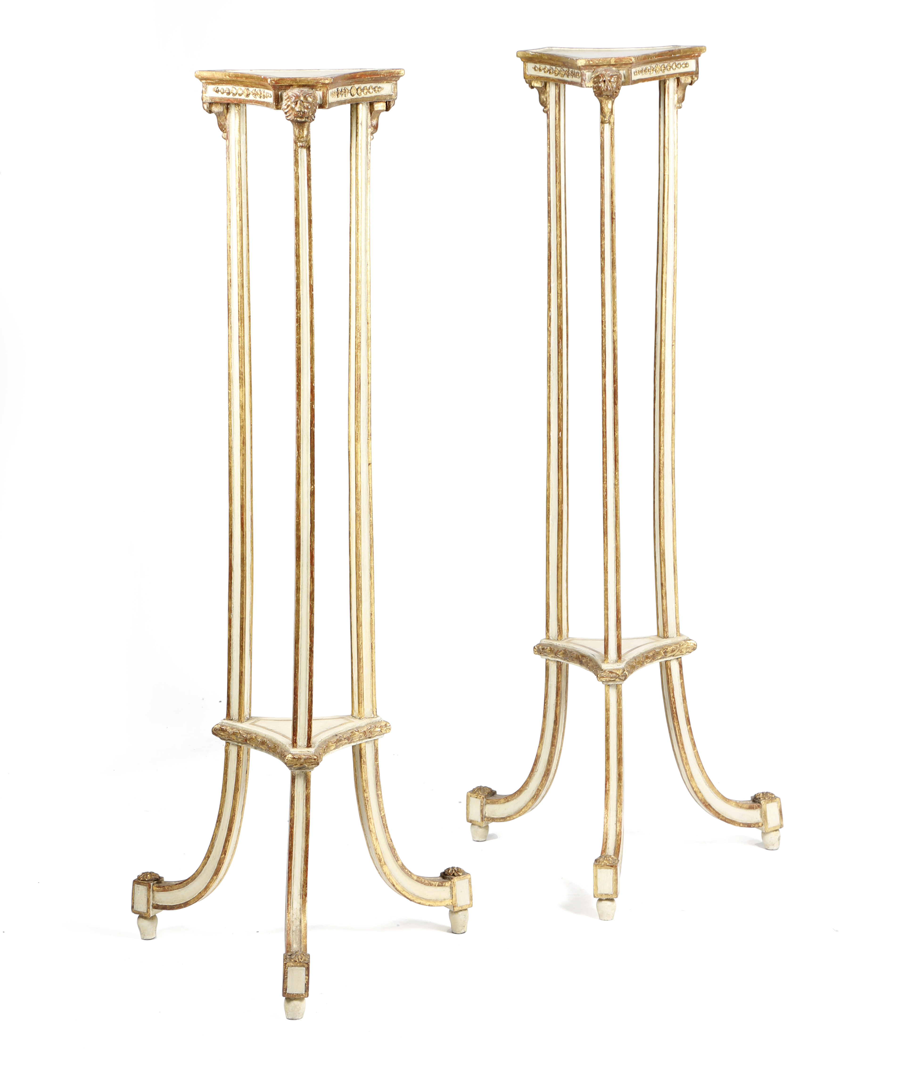 A PAIR OF GEORGE III CREAM PAINTED AND PARCEL GILT TORCHERES C.1790 of open concave form,