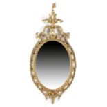 A GEORGE III GILTWOOD WALL MIRROR C.1770 the later oval plate within a gadrooned inner frame and a