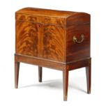 A LATE GEORGE III MAHOGANY CELLARET C.1800-10 inlaid with boxwood stringing, the domed hinged lid