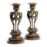 A PAIR OF GEORGE IV BRONZE CANDLESTICKS c.1825 each with nulled decoration, the urn shape nozzle