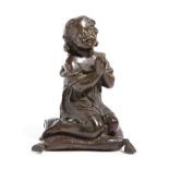A FRENCH BRONZE FIGURE OF A YOUNG GIRL PRAYING 19TH CENTURY seated on a tasselled cushion,