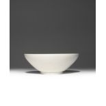 A CHINESE XING WHITE GLAZED BOWL FIVE DYNASTIES The deep body raised on a short flared foot,