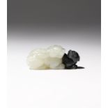 A SMALL CHINESE WHITE AND BLACK JADE CARVING OF LION DOGS QING DYNASTY OR LATER Cleverly carved with